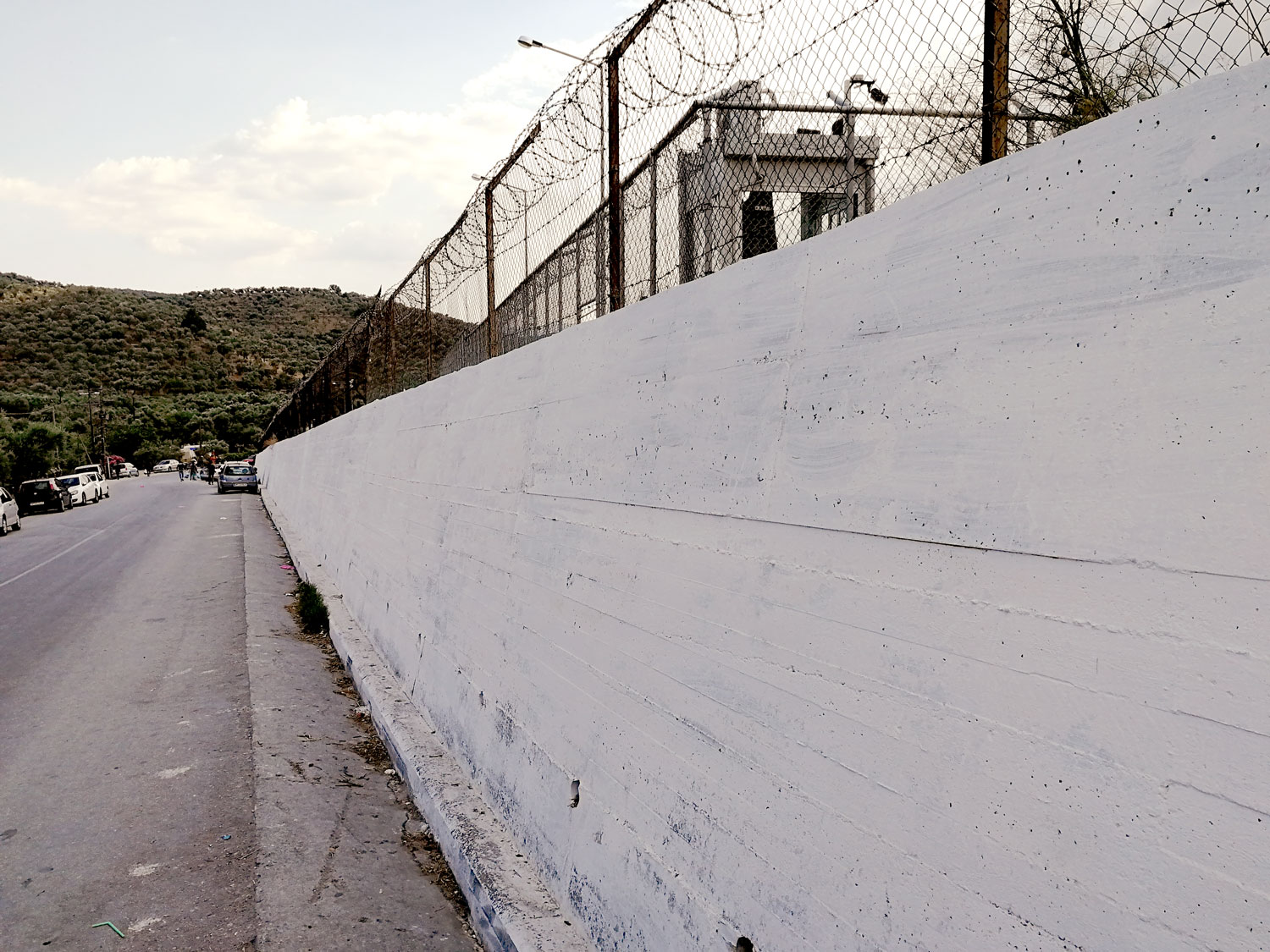 People waiting near a European border wall